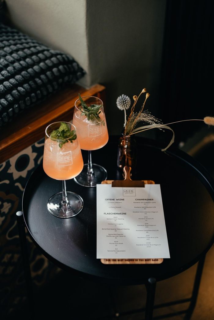 Zwei Spritz-Gläser mit frischer Minze neben der Weinkarte der REBE